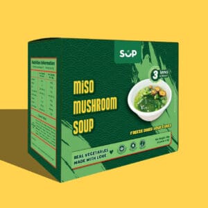 Packaged miso and mushroom soup box with "freeze dried soup cubes" label and nutrition information, against a yellow background.